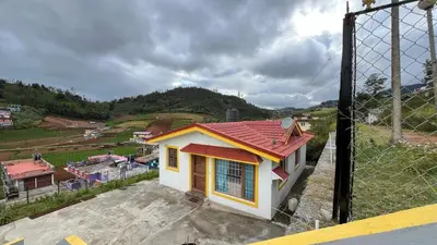 a small house sitting on top of a hill at Chillz Heaven Resorts - Ketti Palada in Coonoor