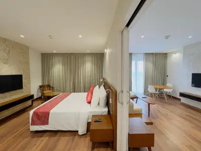 a hotel room with a bed and a living room at Gokulam Grand Kozhikode in Kozhikode