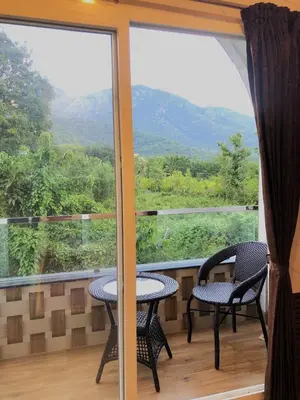 a balcony with two chairs and a table and a window at Galaxy Garden Resort in Kallār