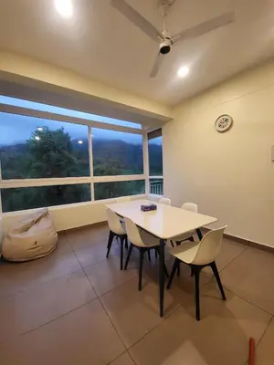 a dining room with a table and chairs and a window at Mountain Serenity Meppadi, Wayanad in Kalpetta