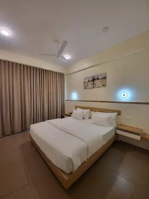 a bedroom with a large white bed in a room at Mountain Serenity Meppadi, Wayanad in Kalpetta