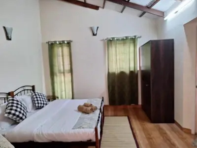 a bedroom with a bed and a wooden floor at Pristine Stay by LexStays in Coonoor