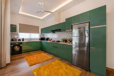 a kitchen with green cabinets and a refrigerator at Le Jardin - Luxury Private Pool Villa near Kochi, Kerala in Ernakulam