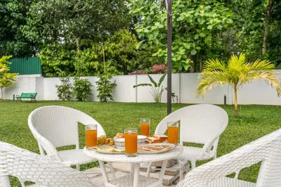 a table with two chairs and a table with orange juice at Le Jardin - Luxury Private Pool Villa near Kochi, Kerala in Ernakulam