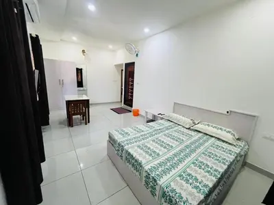 a white bedroom with a bed and a table at Aagneyam mansion in Kozhikode