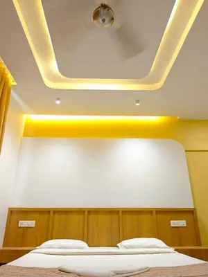 a room with a bed with a yellow ceiling at GIRASSOL the hill villa in Vythiri