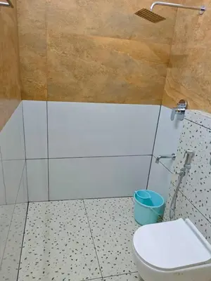 a bathroom with a toilet and a blue bucket at GIRASSOL the hill villa in Vythiri