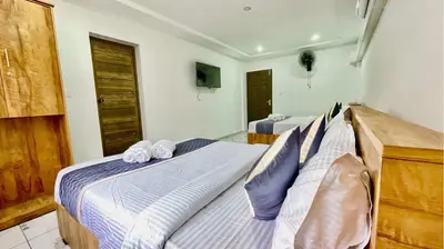 a bedroom with two beds and a tv in it at Brighton Stays in Sultan Bathery