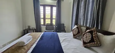 a bedroom with a bed with pillows and a window at Brighton Stays in Sultan Bathery