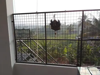 a cage with a view of a field from a window at Brighton Stays in Sultan Bathery