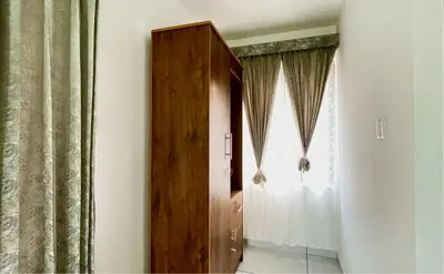 a room with a wooden door and a window at Brighton Stays in Sultan Bathery