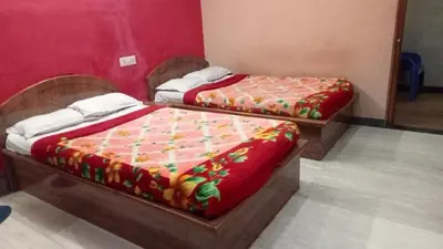 two beds in a room with red walls at Sri Sapthagiri comfort in Mysore