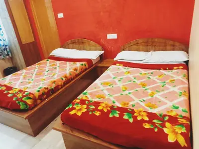 two beds sitting next to each other in a room at Sri Sapthagiri comfort in Mysore