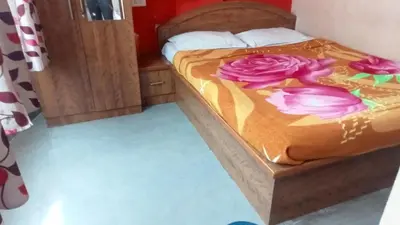a bedroom with a bed with purple flowers on it at Sri Sapthagiri comfort in Mysore