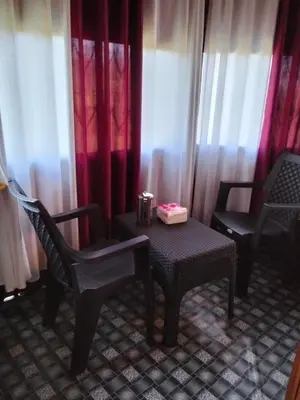 a room with two chairs and a table with a candle at LilliputHaven Treehut in Sultan Bathery