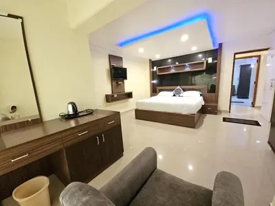 a large room with a bed and a couch in it at R R K Residency in Ooty
