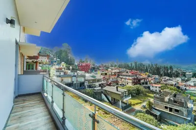 a balcony with a view of a city at Super Collection O Charing Cross Ooty in Ooty