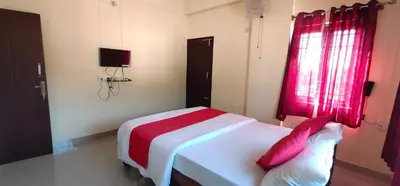 a bedroom with a bed with a red window at Shanthala Residency in Virajpet