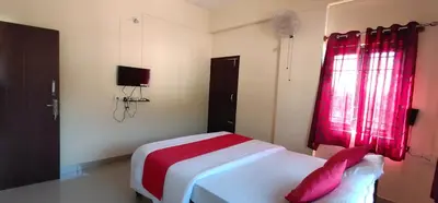 a bedroom with a bed with a red window at Shanthala Residency in Virajpet