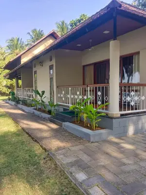 a house with a porch and plants in front of it at Bharathapuzha resort in Kārakkād