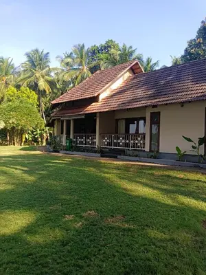 a house with a lawn in front of it at Bharathapuzha resort in Kārakkād