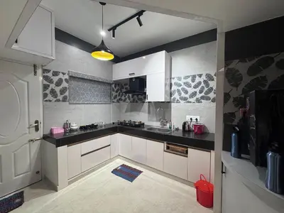 a kitchen with white cabinets and black counter tops at Vels Villa A home away from home at Pollachi in Pollāchi