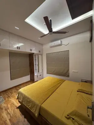 a bedroom with a large bed with a ceiling fan at Vels Villa A home away from home at Pollachi in Pollāchi
