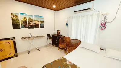 a bedroom with a bed and a desk and a window at Voitto Vista in Cochin