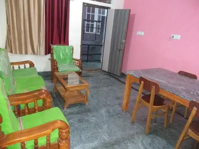a room with chairs and a table and a table and chairs at Sri Sai Residency Ooty in Ooty