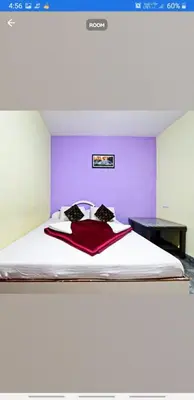 a bedroom with a large bed with a purple wall at Sri Sai Residency Ooty in Ooty