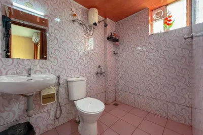 a bathroom with a toilet and a sink at Stella Marries Airpot Lounge in Nedumbassery