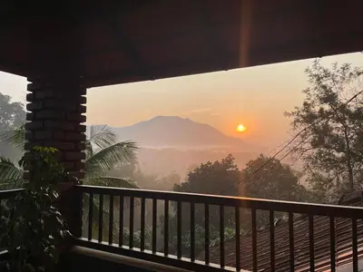 a view from the balcony of a house with the sunset at CASTELLO Holiday Villa in Kalpetta