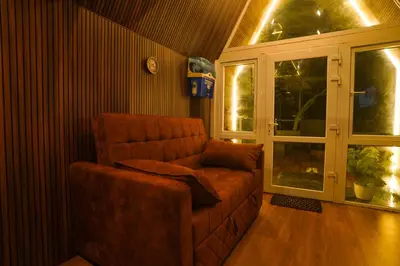 a living room with a couch and a window at Casa de Selas - A Chalet Stay in Coonoor