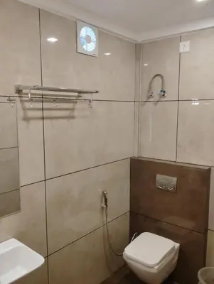 a bathroom with a shower with a toilet and a sink at Grand UNX in Kannur