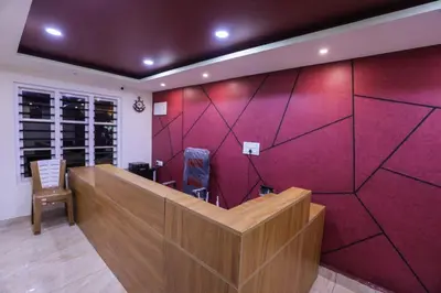 a lobby with a red accent wall and a desk at Velvet Oasis Cottages in Vythiri