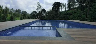 a swimming pool in the middle of a forest at Velvet Oasis Cottages in Vythiri
