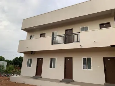 a large white building with doors and a balcony at V Nature Resorts in Kanakapura