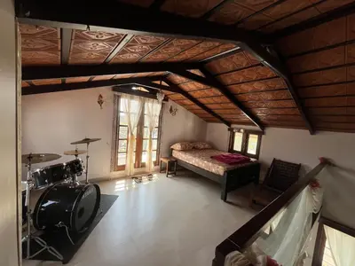 a room with a bedroom with a bed and a table at Aaloka stay in Mysore