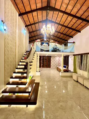 a large lobby with a staircase and a chandelier at Aaloka stay in Mysore