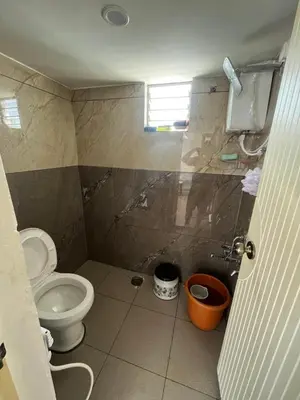 a small bathroom with a toilet and a window at Aaloka stay in Mysore