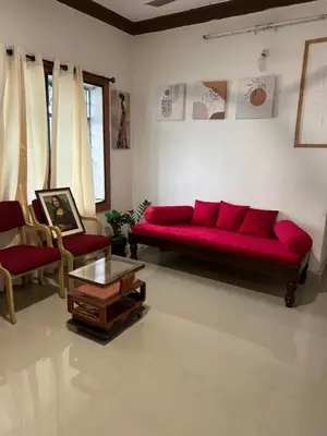 a living room with a red couch and two chairs at Sogni D oro in Mysore
