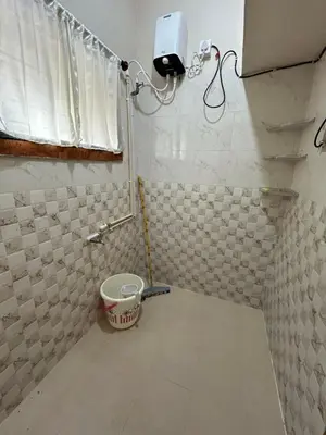 a bathroom with a bucket in the corner of a room at Sogni D oro in Mysore