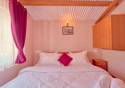 a bedroom with a white bed with purple curtains at Silver Dale Tea Estate Bungalow Ooty by VOYE HOMES in Ooty