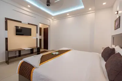 a bedroom with a large bed with a tv on the wall at Cochin Airport Hotel in Ernakulam