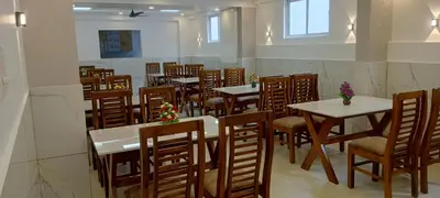 a restaurant with tables and chairs in a room at Cochin Airport Hotel in Ernakulam