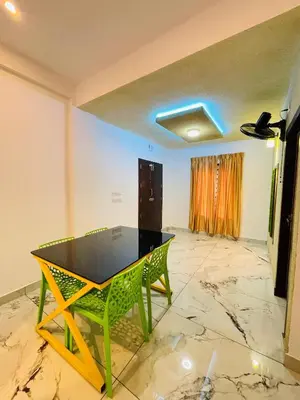 a dining room with a table and a green chair at Tea vista holiday home in Kalpetta