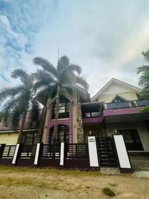 a house with palm trees in front of it at Stay Easy - Potta, Athirapally Road in Kizhake Chālakudi
