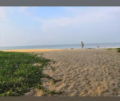 a person standing on a sandy beach near the ocean at Katadi beach home in Thanniyam