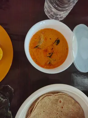 a table with a bowl of soup and a plate of food at Katadi beach homestay in Trichūr