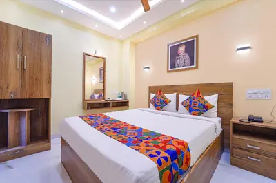 a bedroom with a large bed and a mirror at FabHotel INK - Nr Coimbatore North Railway Station in Coimbatore